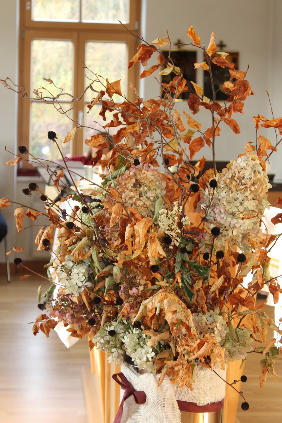 Fotos der Verstorbenen auf Engelsflügerl und schöner Herbstdeko geschmückt.