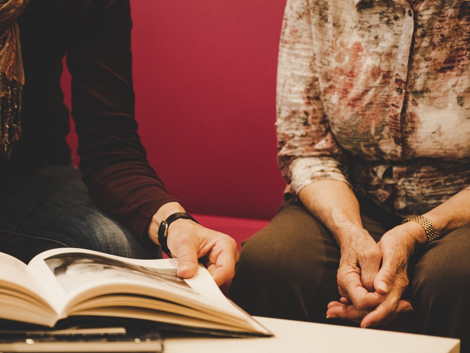 Bewohnerin und Betreuerin sitzen nebeneinander.