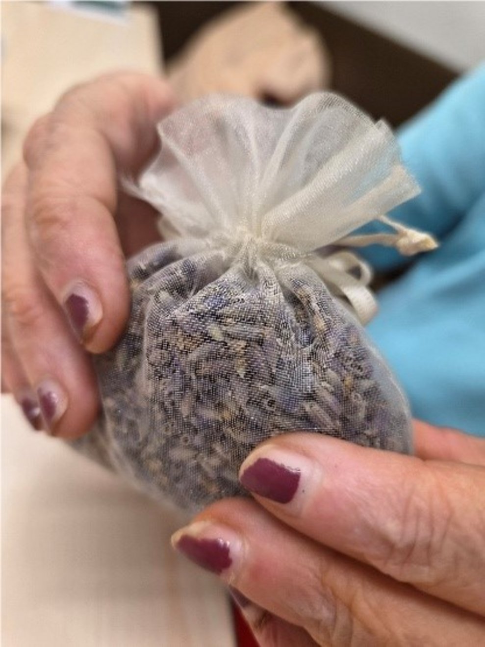 Bewohnerin hält ein Säckchen mit Lavendel in den Händen.