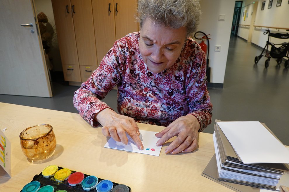 Bewohnerin gestaltet eine Osterkarte