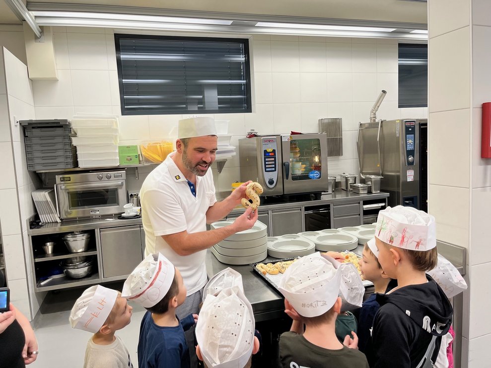 Thomas zeigt den Kindern die Brotteig Buchstaben