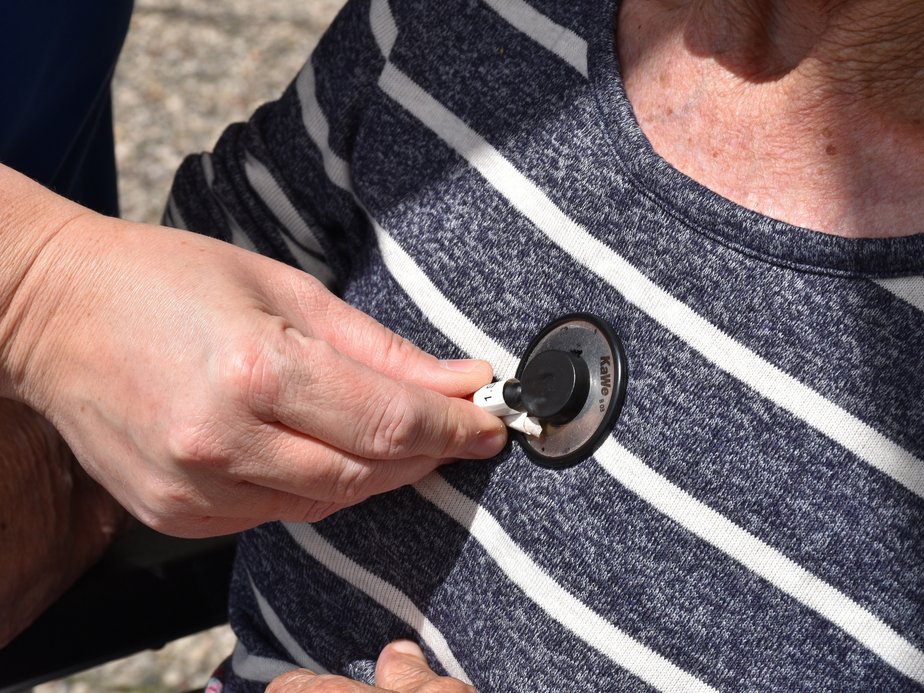 Eine Bewohnerin wird mit einem Stethoskop abgehört.