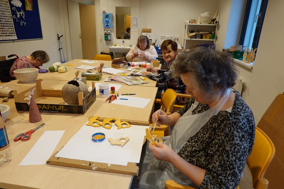 Bewohnerinnen bemalen Holzosterhasen