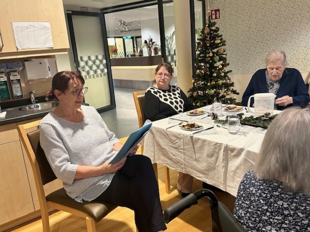 an einer festlich geschmückten Tafel zusammen.