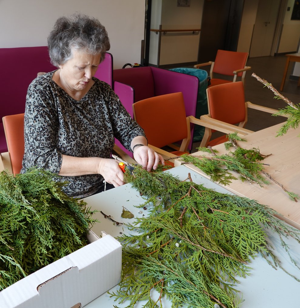 Bewohnerin bindet einen Palmbuschen