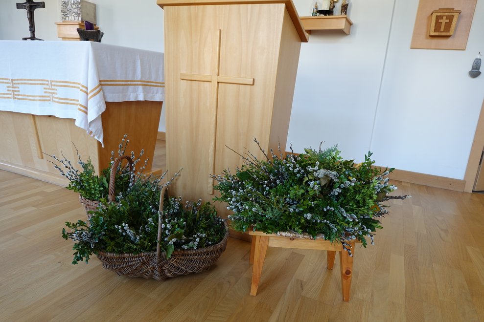 Palmbuschen im Korb stehen vorm Altar