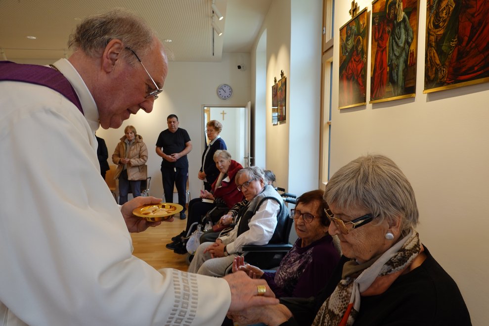 Bischof Schwarz verteilt die Kommunion an unsere Bewohnerinnen und Bewohner.