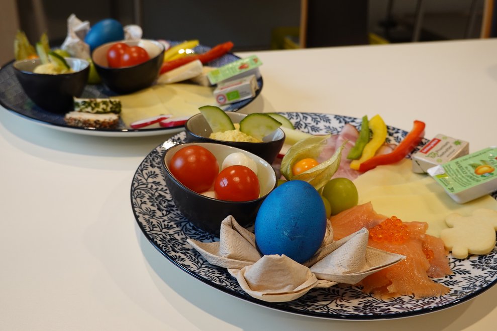 Teller mit Osterfrühstück, gefärbtes Ei, Lachs, Käse, Gemüse, Obst