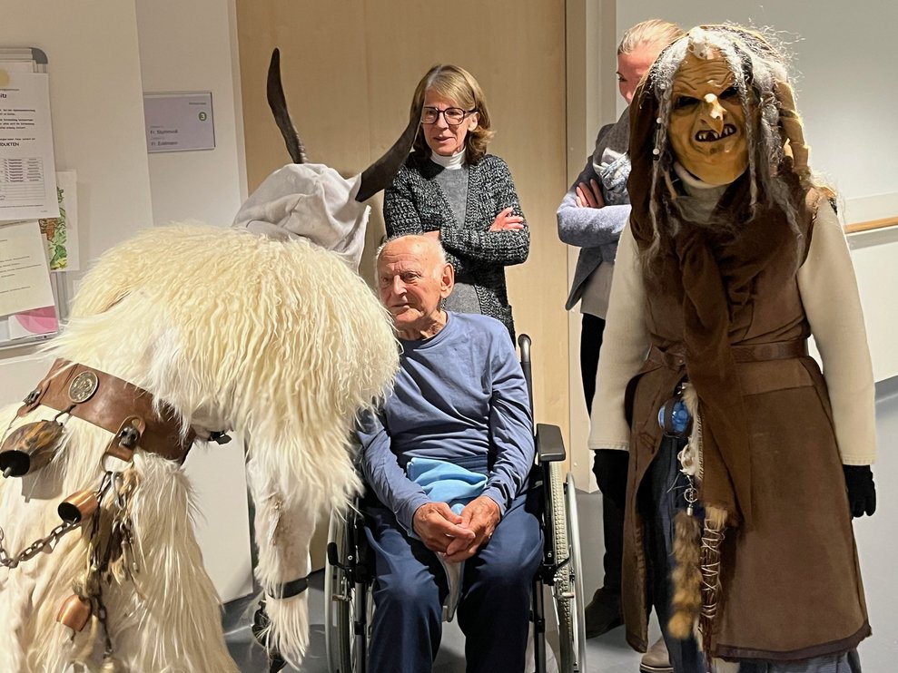 Percht und Hexe reden mit einem Bewohner