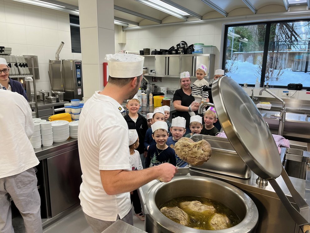 Die Kinder bestaunen den großen Suppentopf.